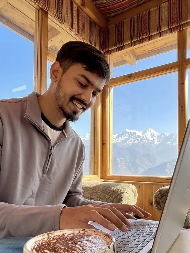Dr. Raghav Hugar, founder of Corporate Doctor, working remotely on his laptop with a Himalayan mountain view